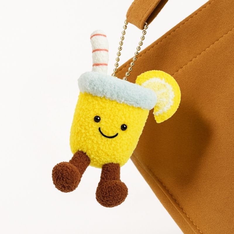 Cute lemon water crochet plush keychain from Puddingcase, hanging on a brown handbag, perfect as a DIY bag charm accessory